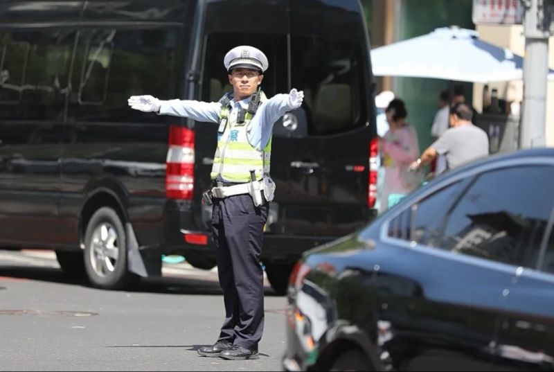 在金宝街西口，东城交通支队东单大队的交警在烈日下执勤，保障道路交通有序畅通。