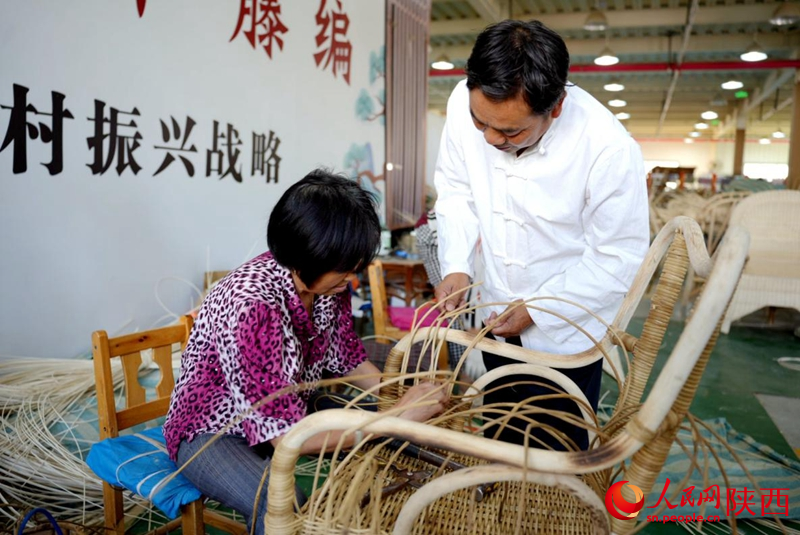 行进中国|藤编“上新” 陈良顺(右)正在教授工人藤编技艺。人民网记者 邹星摄